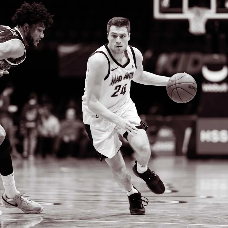 A basketball player dribbling down the court